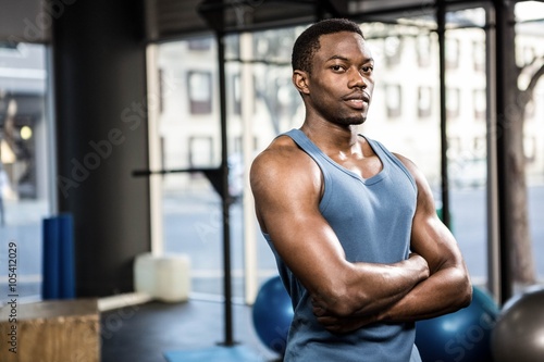 Muscular man standing with arms crossed