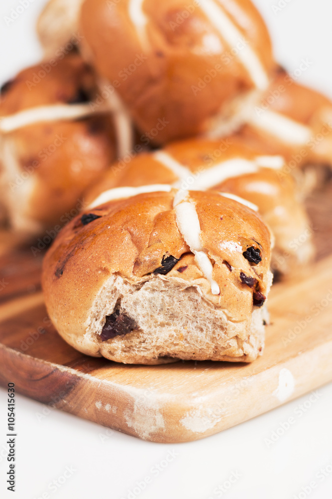 Hot cross buns on a timber board with a white background. Hot cross buns on a timber board with a white background.