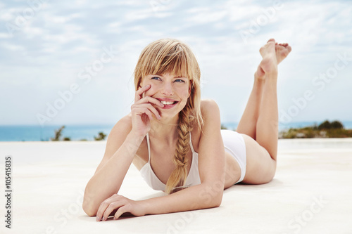 Beautiful woman lying on front at poolside