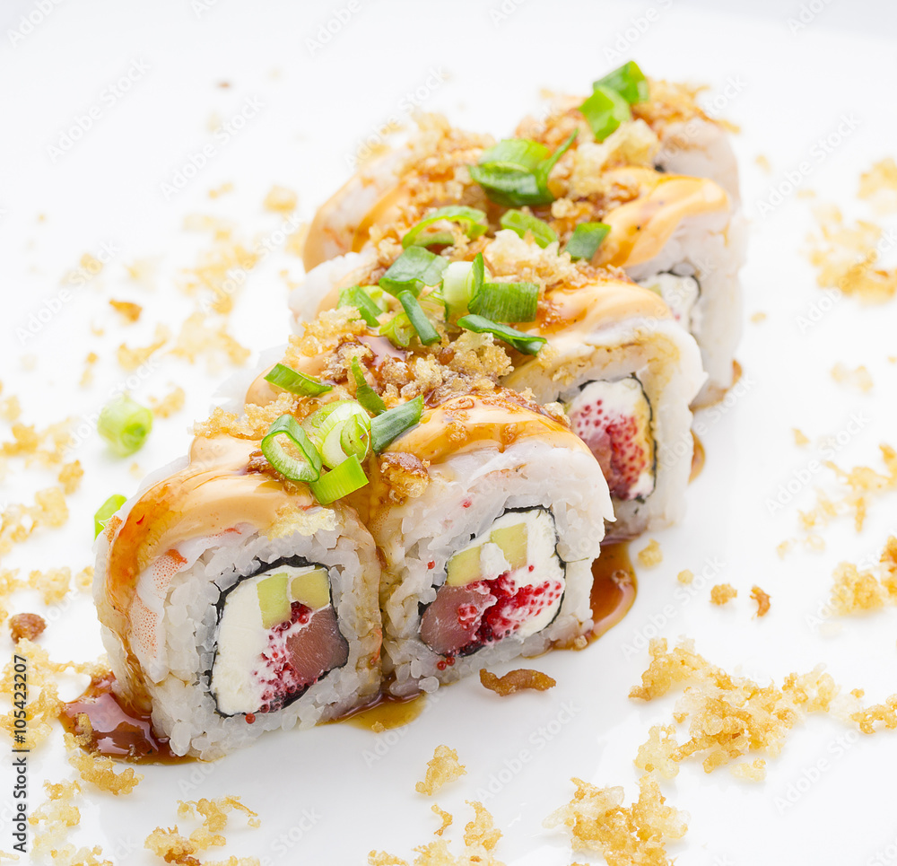 Sushi with shrimp avocado salmon and cheese strewed with green onion. Crunch Roll. With delicious sauces. Over white background. Sushi with shrimp avocado salmon and cheese strewed with green onion. Crunch Roll. With delicious sauces. Over white background.