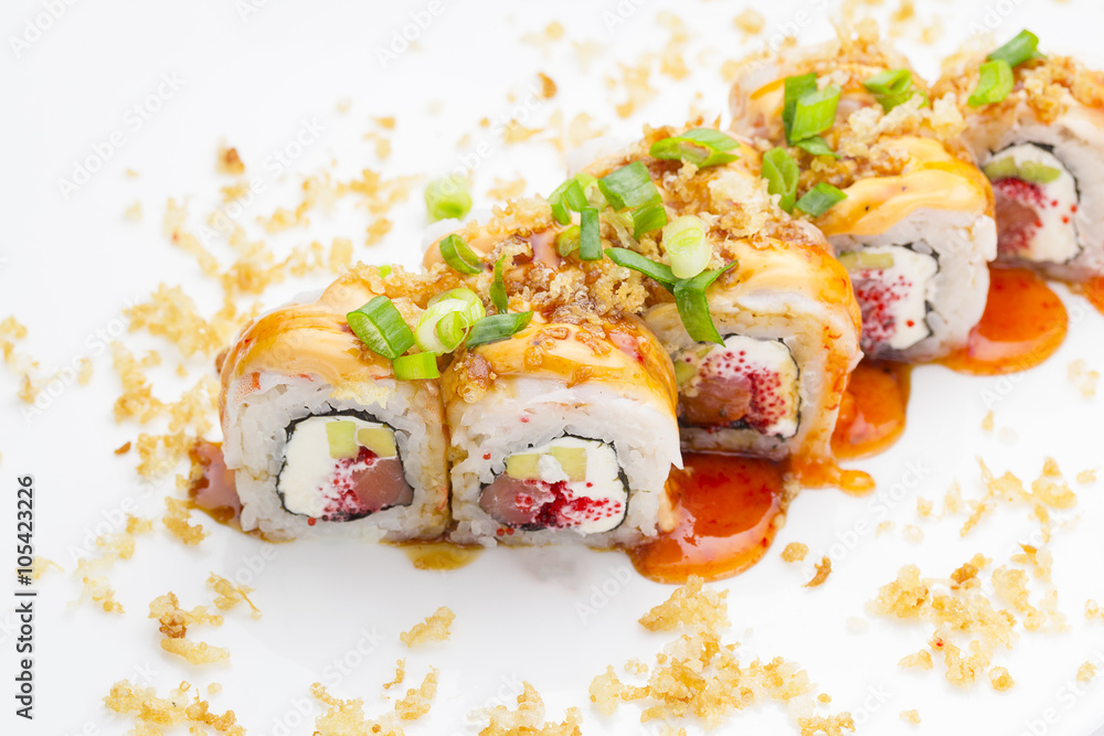 Sushi with shrimp avocado salmon and cheese strewed with green onion. Crunch Roll. With delicious sauces. Over white background. Sushi with shrimp avocado salmon and cheese strewed with green onion. Crunch Roll. With delicious sauces. Over white background.