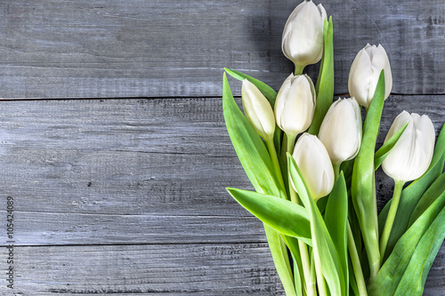 Fototapeta Naklejka Na Ścianę i Meble -  White tulips flowers on wooden table with copy space, top view, vintage photo
