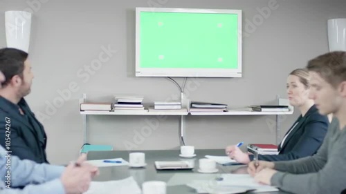 Colleagues have a discussion at the meetingroom in front of a greenscreen photo