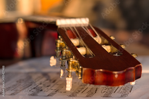 Guitar headstock on music notes, close up