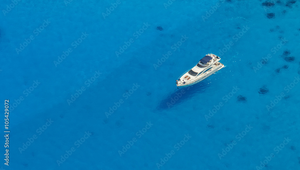 Naklejka premium Aerial view of single yacht in azure sea