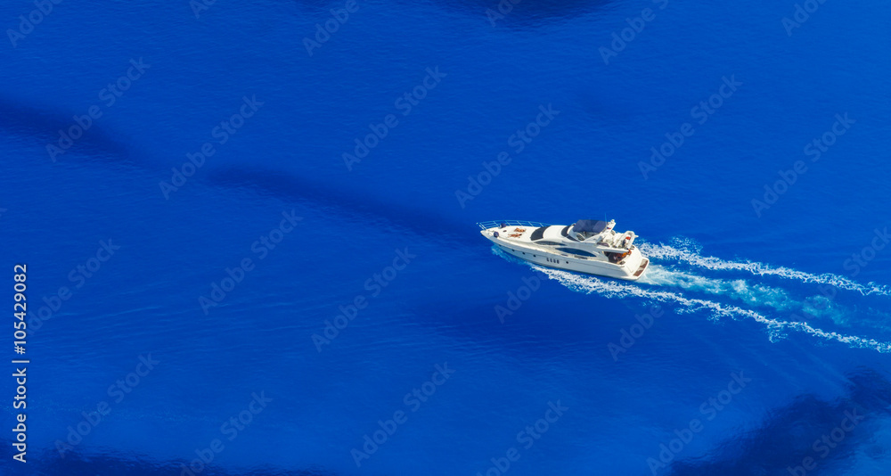 Obraz premium Aerial view of single yacht in azure sea