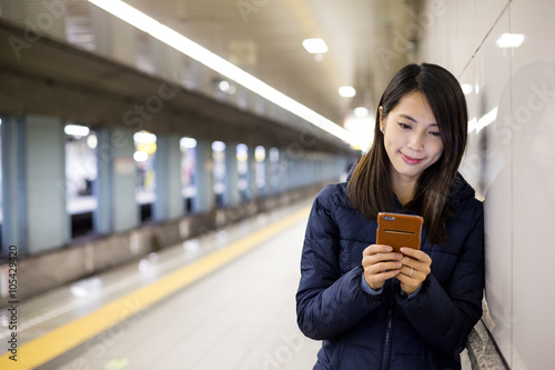 Photography Young woman use of mobile phone in tokyo city metro