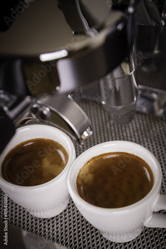 two cups of espresso poured from a espresso machine 