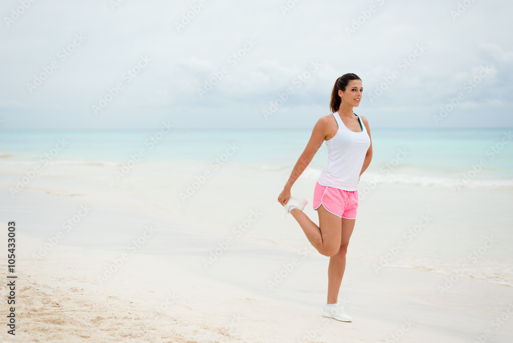 Fitness woman stretching legs for warming up before running or exercising at the beach. Healthy lifestyle on summer. Fitness woman stretching legs for warming up before running or exercising at the beach. Healthy lifestyle on summer.