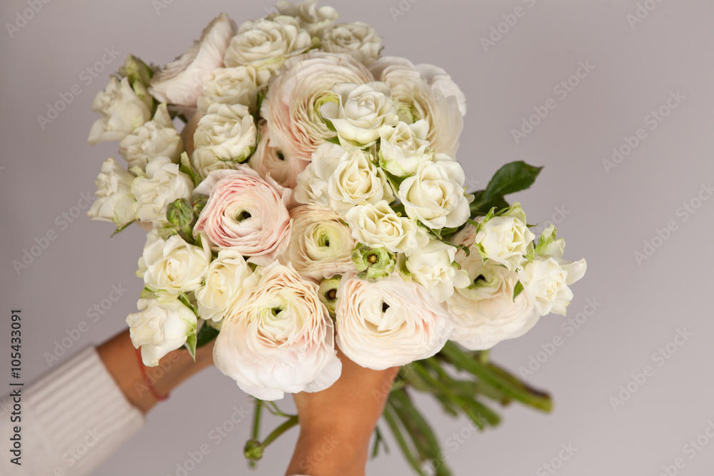 Obraz premium Beautiful bouquet of ranunculus and roses in woman hands.