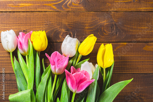 Fototapeta Naklejka Na Ścianę i Meble -  Bouquet Of Tulips In Front Of Spring Scene On The Wooden Background. A bouquet of flowers for March 8, or Valentine's day