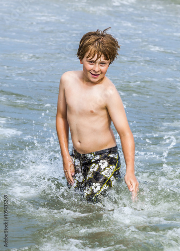 Fototapeta Naklejka Na Ścianę i Meble -  boy enjoys the waves in the ocean