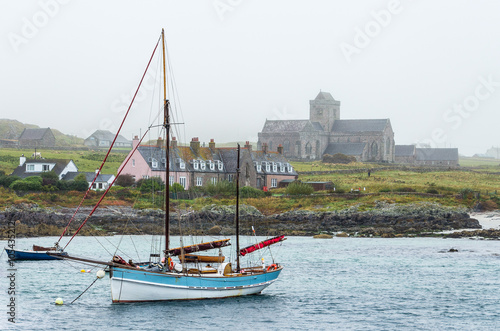 Obraz na płótnie Vintage schooner sailboat with furled sails moored at Iona island natural port close to Mull, in the Inner Hebrides of Scotland