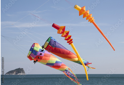colored kites in a windy day in ligurian riviera, italy