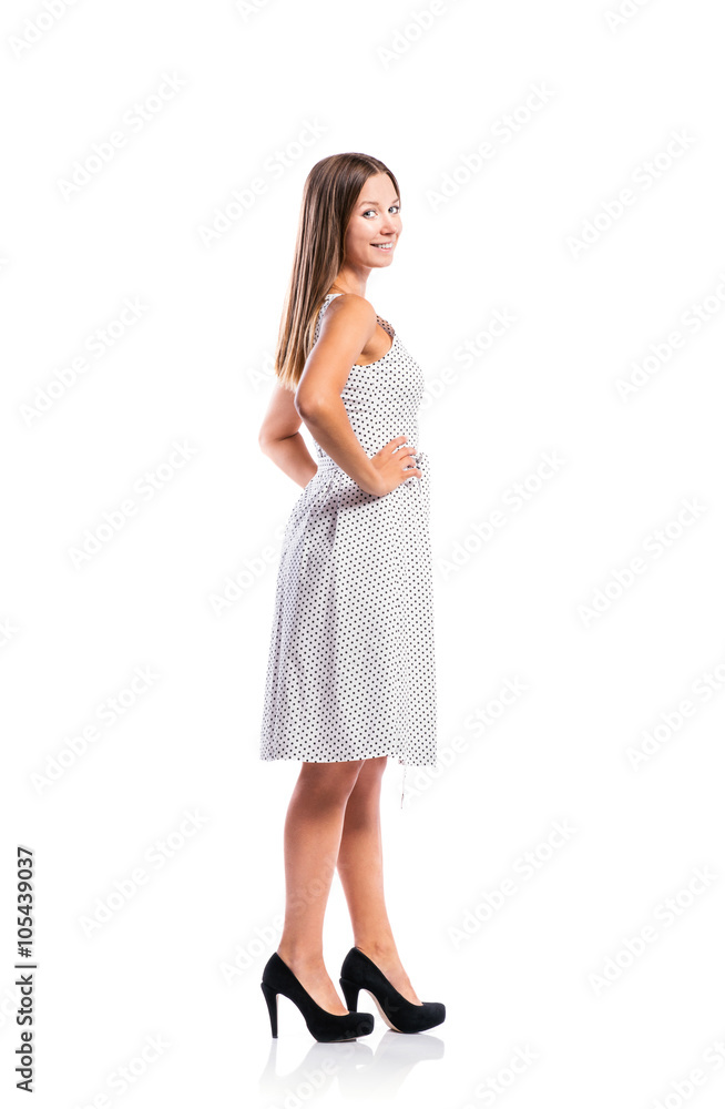 Girl in black-and-white dotted dress, heels, studio shot Girl in black-and-white dotted dress, heels, studio shot
