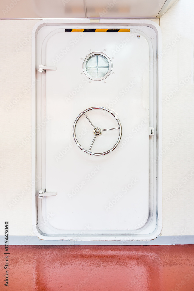 Fototapeta premium White closed watertight door in a ship. The door provides a functional barrier between watertight bulkheads.