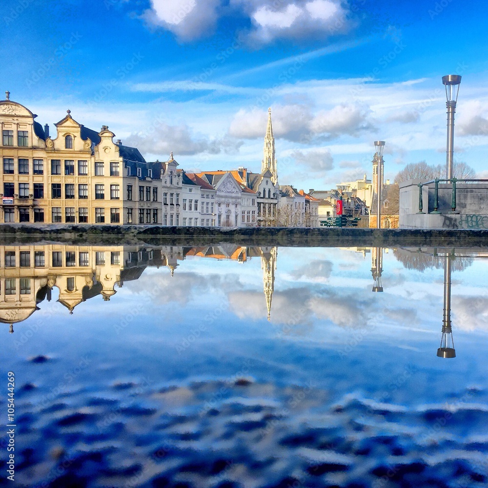 city of brussels reflected in a puddle