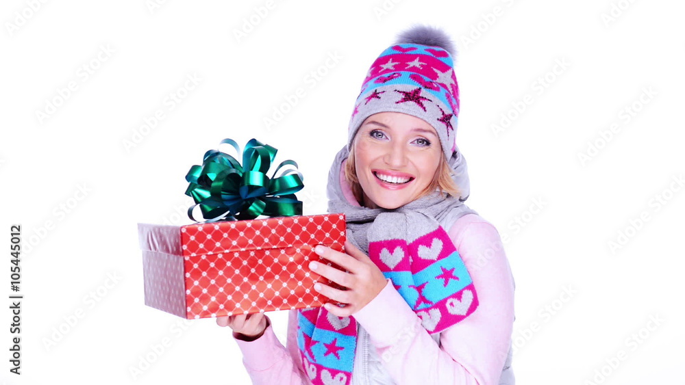 Happy surprised adult woman with christmas gift in hands, in a winter clothes posing at studio Happy surprised adult woman with christmas gift in hands, in a winter clothes posing at studio