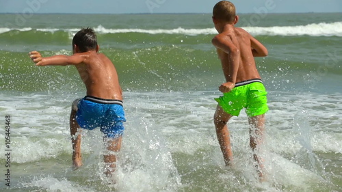 Two happy joyful  children running to the sea water. Slow motion. Full hd 1920x1080 photo