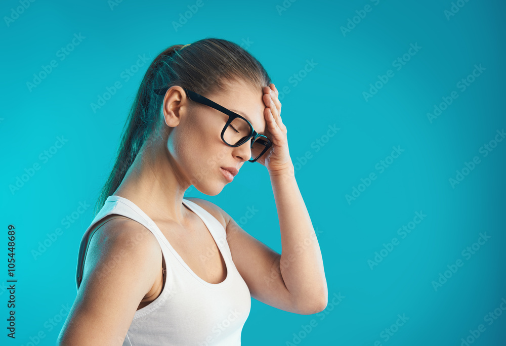 Young female having hangover or vertigo. Studio portrait over blue background. Concept of pain, symptom and health care. Young female having hangover or vertigo. Studio portrait over blue background. Concept of pain, symptom and health care.