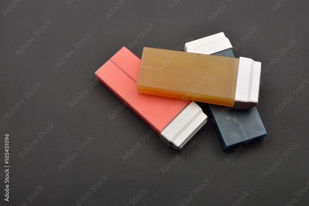 Picture of liposoluble wax cartridges for waxing on black backgr Picture of liposoluble wax cartridges for waxing on black backgr