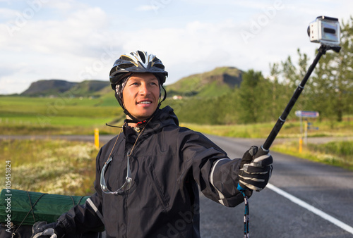 Happy biker doing selfie on backdrop of mountains in Iceland