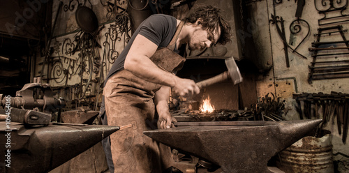 Photography Ironworker forging hot iron in workshop