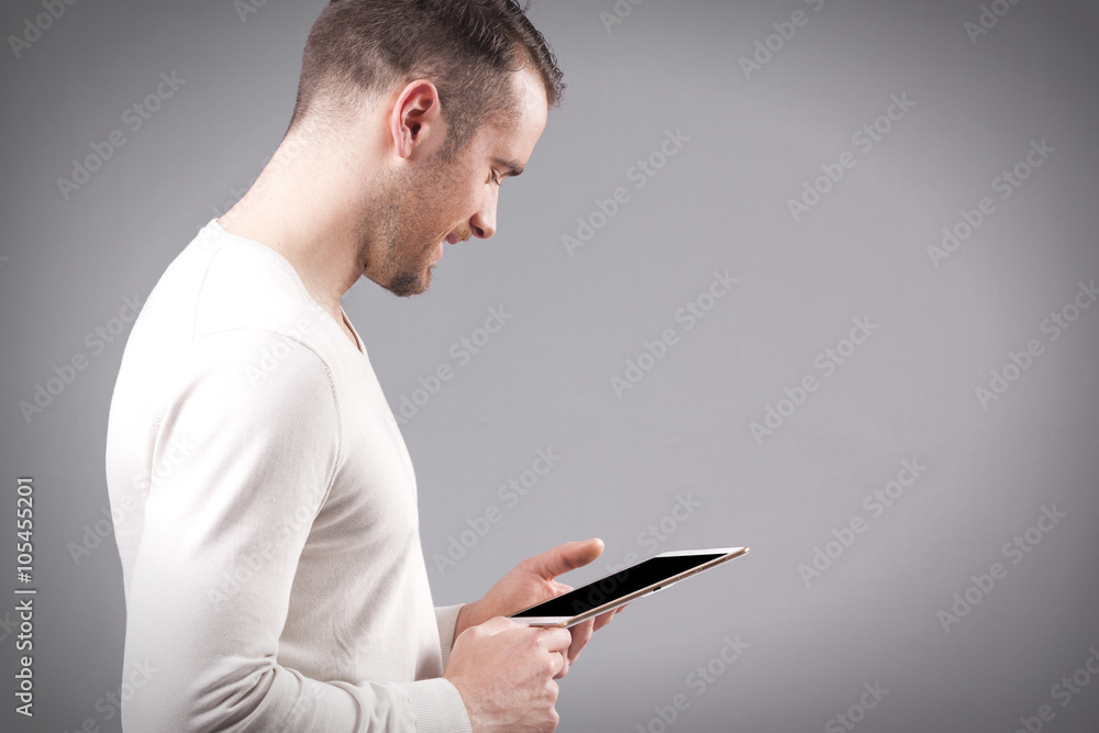 Handsome smiling man holding a digital tablet on grey background Handsome smiling man holding a digital tablet on grey background
