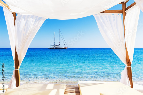 Fototapeta Naklejka Na Ścianę i Meble -  View of the beautiful beach through a Balinese bed