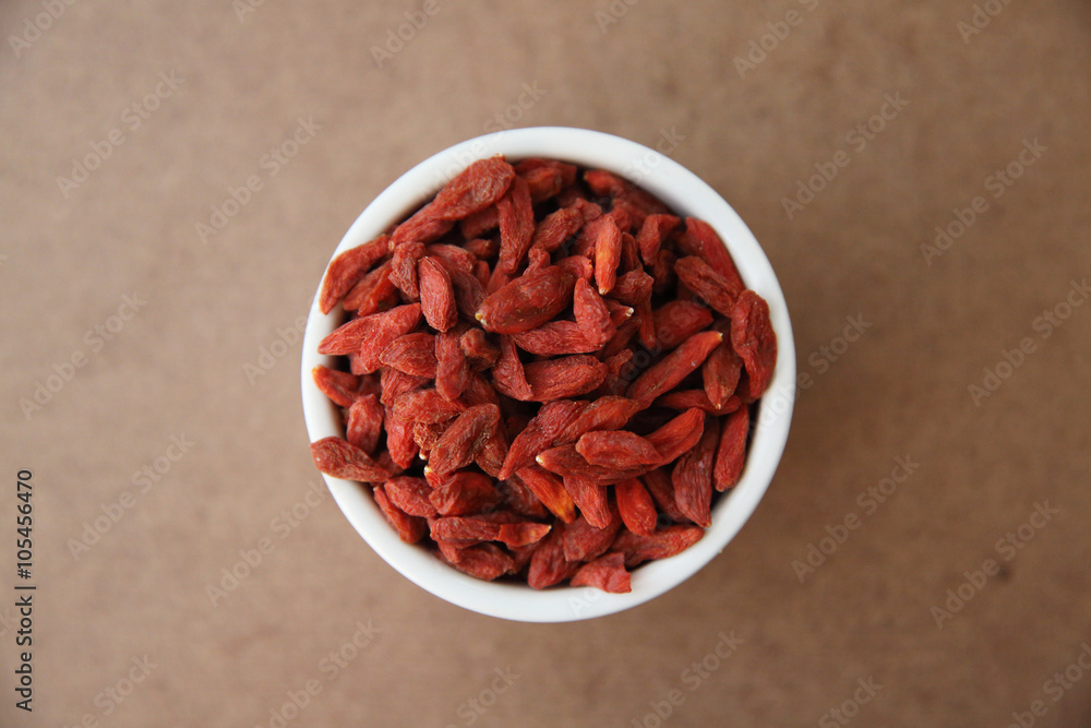 dry red goji berries on wood background dry red goji berries on wood background