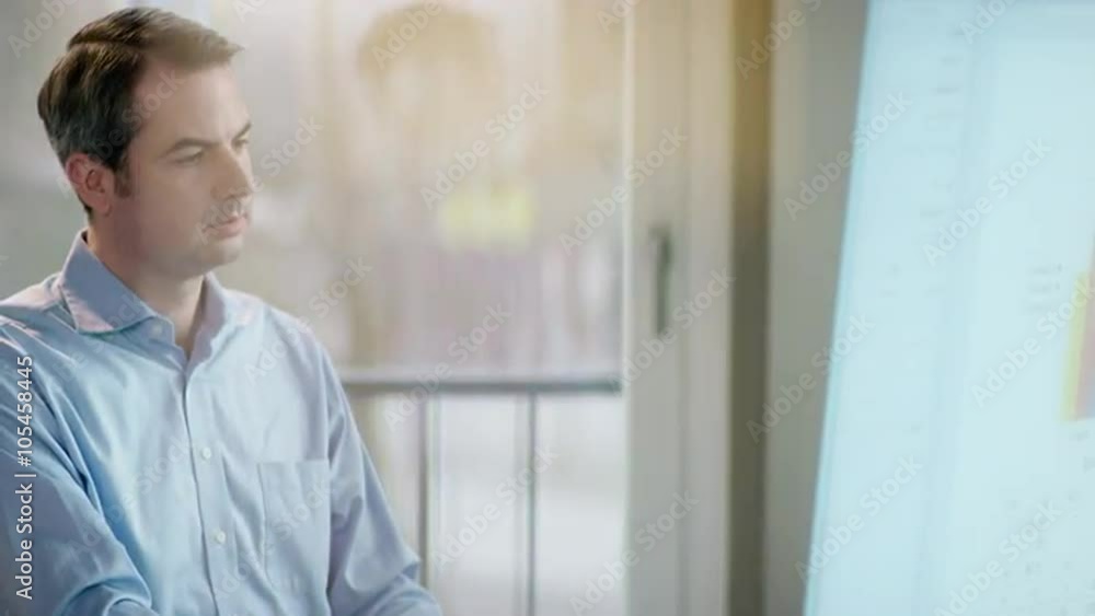 Businessman works focused at his work in front of modern screen Businessman works focused at his work in front of modern screen