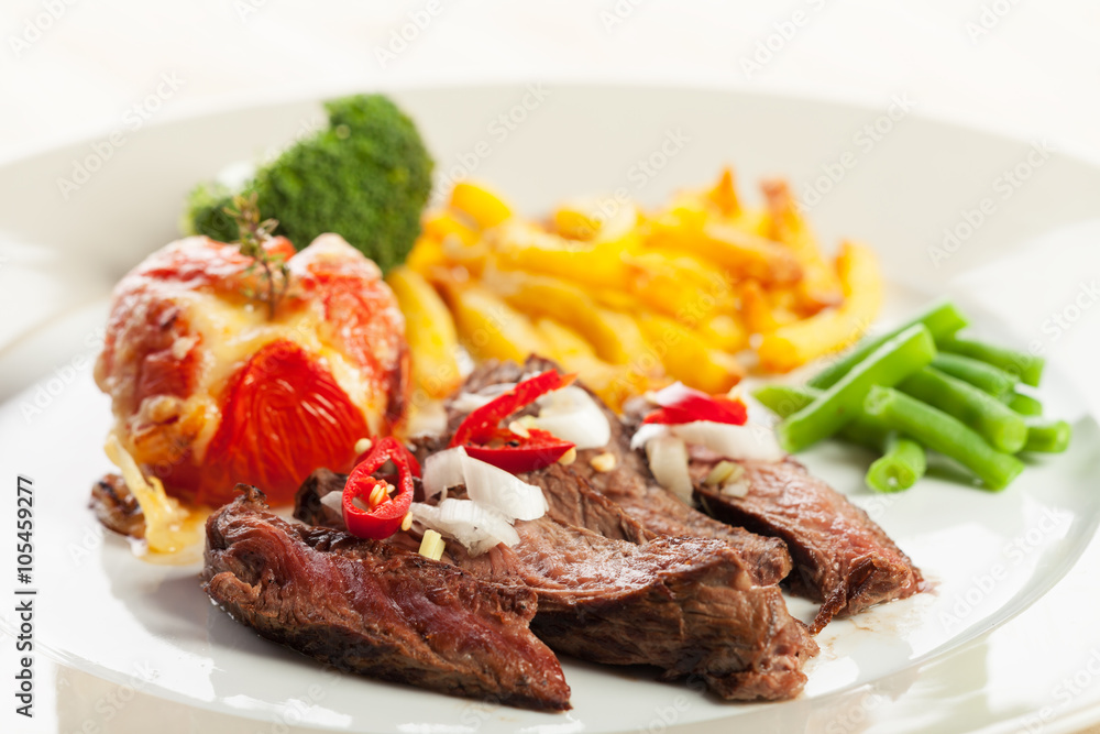 angeschnittenes Steak vom Grill mit Pommes frites und Tomaten angeschnittenes Steak vom Grill mit Pommes frites und Tomaten