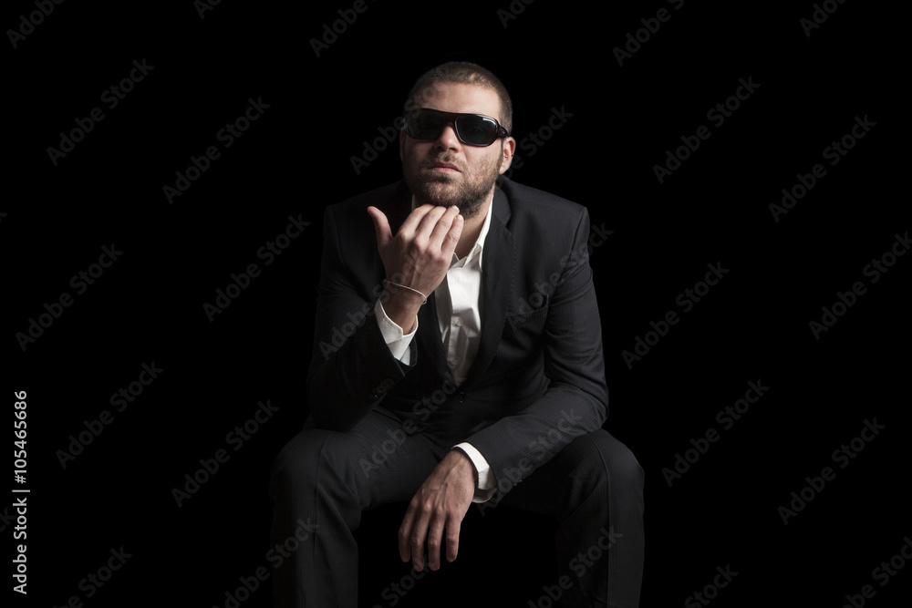 Fototapeta premium portrait of a tough cool man with sunglasses on balck background