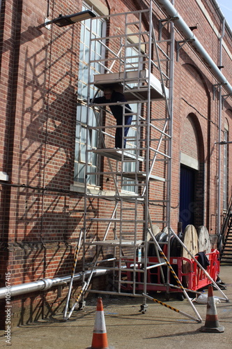 A painter and decorator working from a scaffold tower