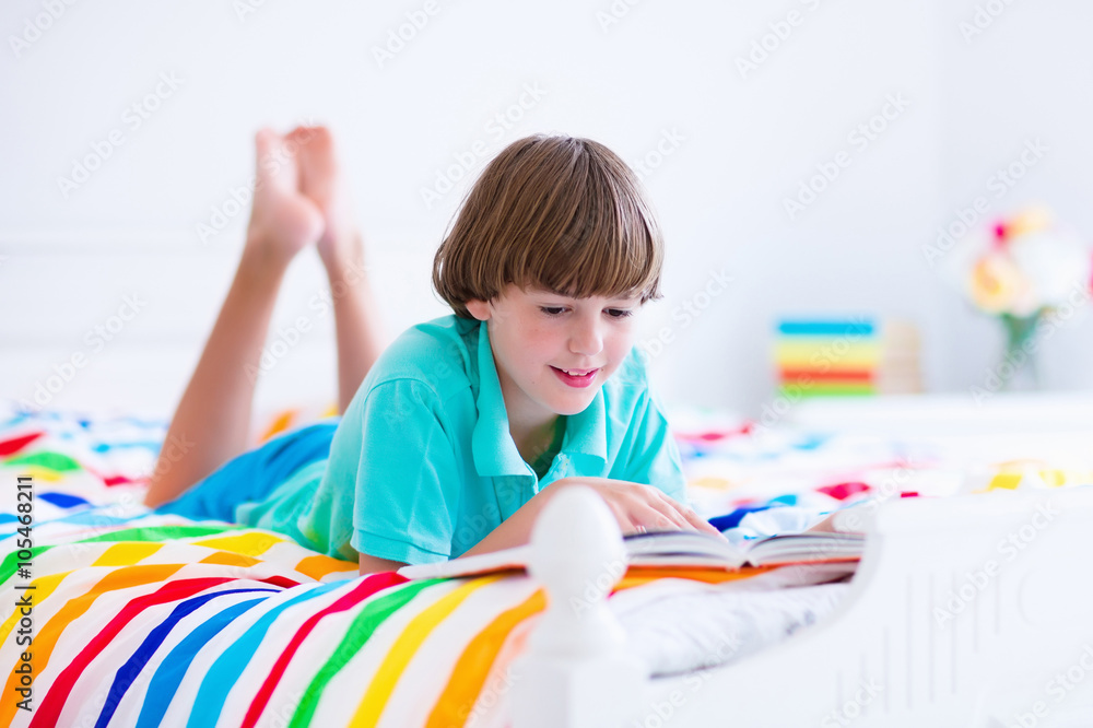 School boy reading a book in bed School boy reading a book in bed