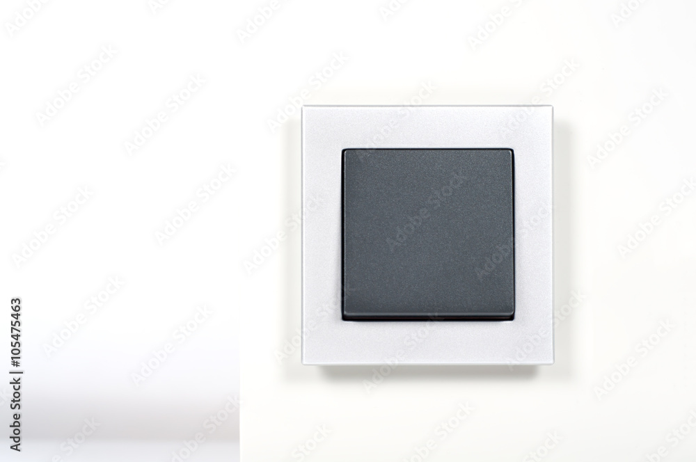 light switch with silver glass frame on the wall