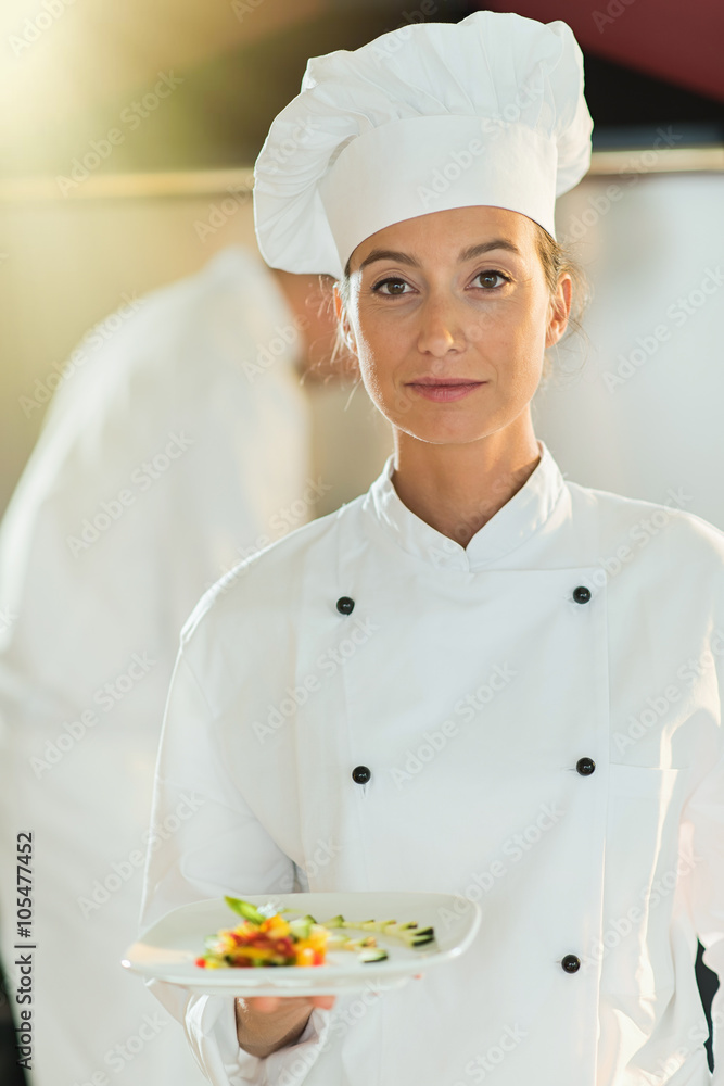 Portrait of a woman chef presenting a plate of fine food. Portrait of a woman chef presenting a plate of fine food.