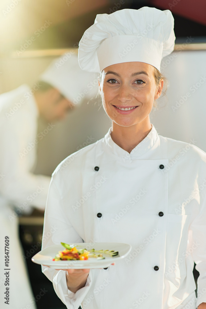 Portrait of a woman chef presenting a plate of fine food. Portrait of a woman chef presenting a plate of fine food.