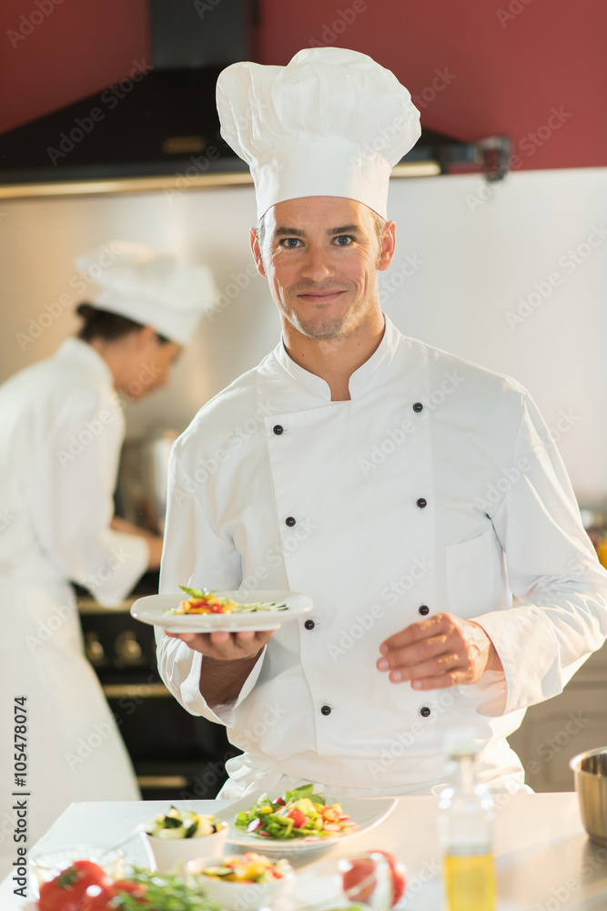 Portrait of a man chef presenting a plate of fine food. Portrait of a man chef presenting a plate of fine food.