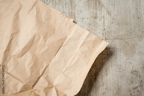Crumpled brown paper on a worn, wooden surface