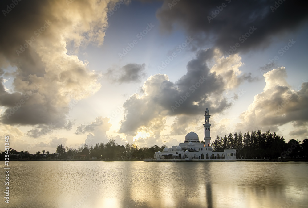 Beautiful white  mosque near the lakeside during sunset. soft cloud and reflection. image taken at Terengganu, Malaysia.
