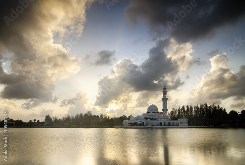 Beautiful white mosque near the lakeside during sunset. soft cloud and reflection. image taken at Terengganu, Malaysia.