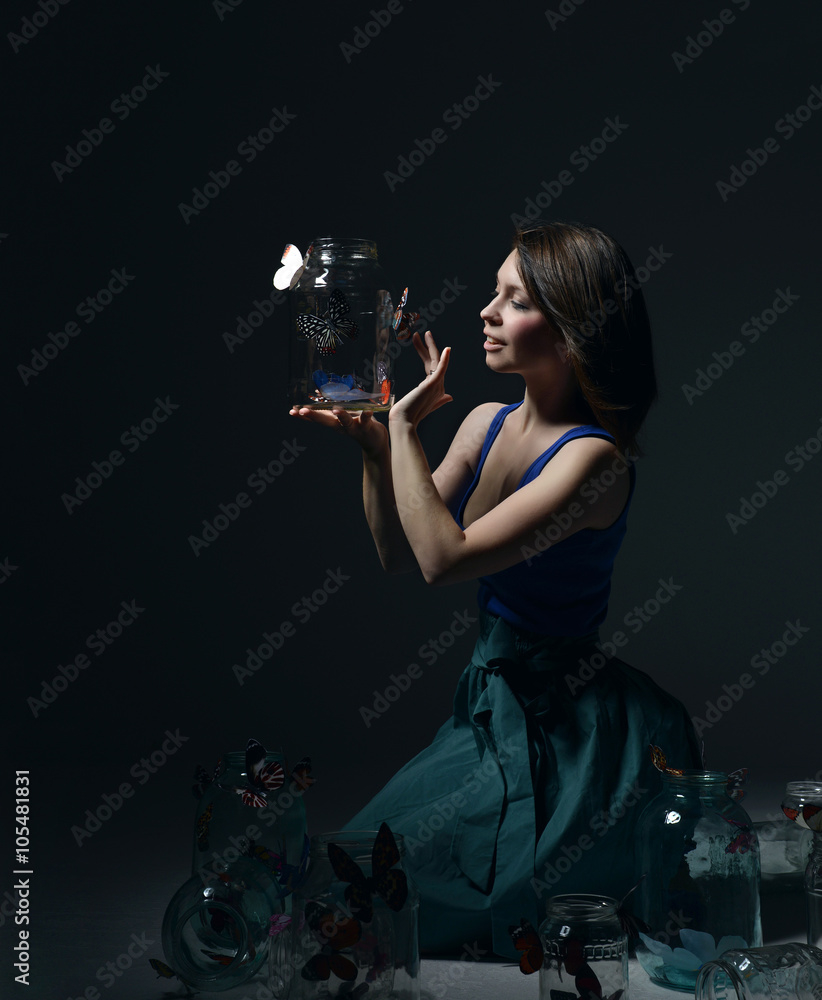Obraz premium Beautiful fashion girl with butterflies in clear glass cans