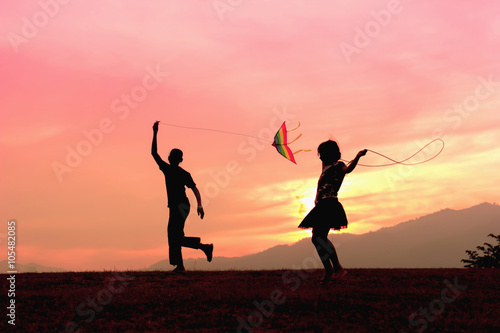 A brother getting a kite to fly and sister rope jumping during s