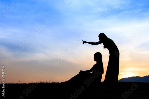 Silhouette happy girls on a meadow at sunset