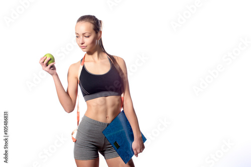 attractive fitness model with measuring tape on a white background