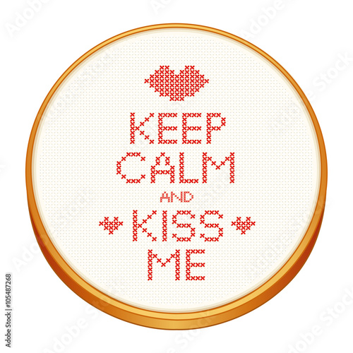 Keep Calm and Kiss Me cross stitch embroidery on wood embroidery hoop with love, a big kiss and hearts, white Aida even-weave cloth texture background needlework sampler isolated on white.
