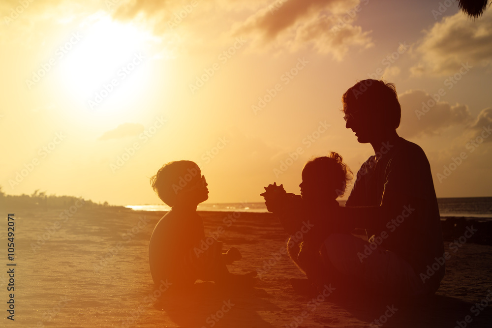father with son and daughter at sunset