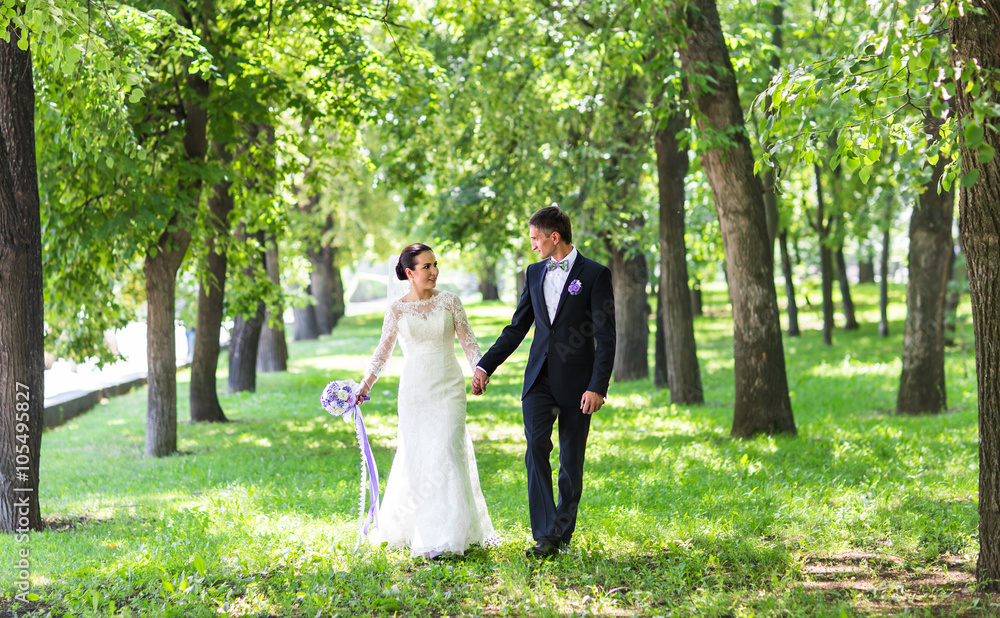 happy beautiful bride and groom walking on a park happy beautiful bride and groom walking on a park