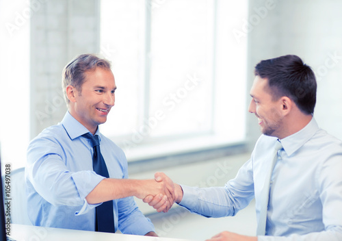 businessmen shaking hands in office